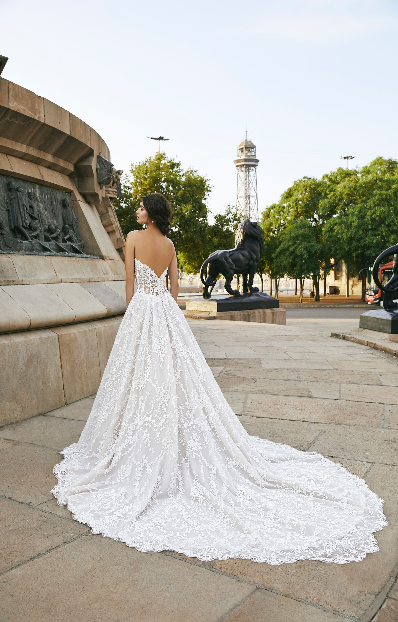 Back of model in Ronald Joyce style 69709, a strapless lace ballgown wedding dress with a sweetheart neckline, illusion bodice and v-shape open back. 