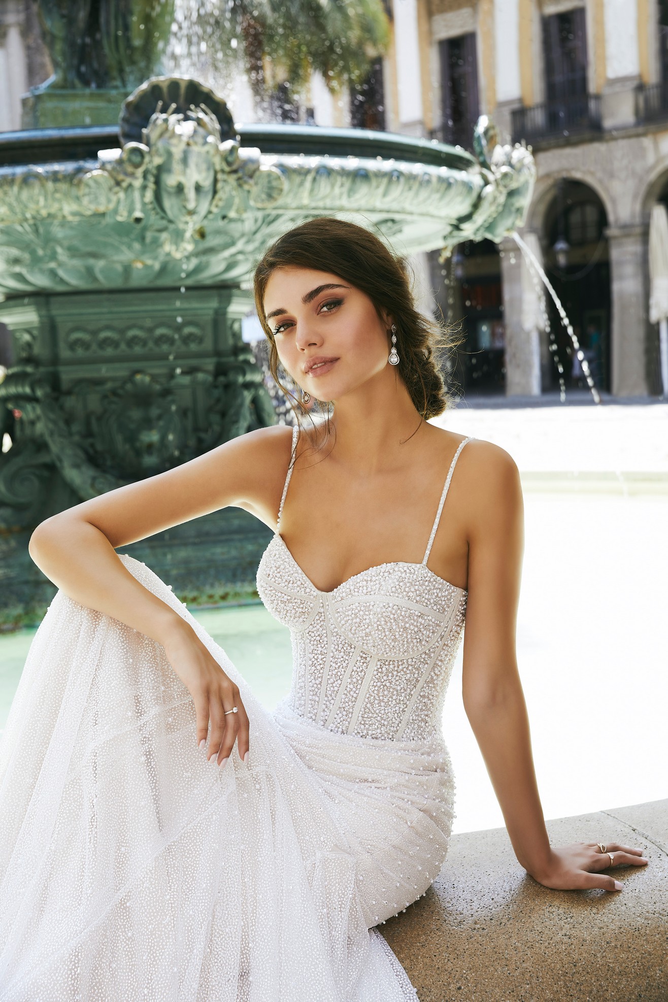 Close up of model wearing Ronald Joyce wedding dress style 69712, an exquisitely pearl-beaded fit and flare gown in glitter tulle with delicate straps and a sweetheart neckline in ivory and champagne. 