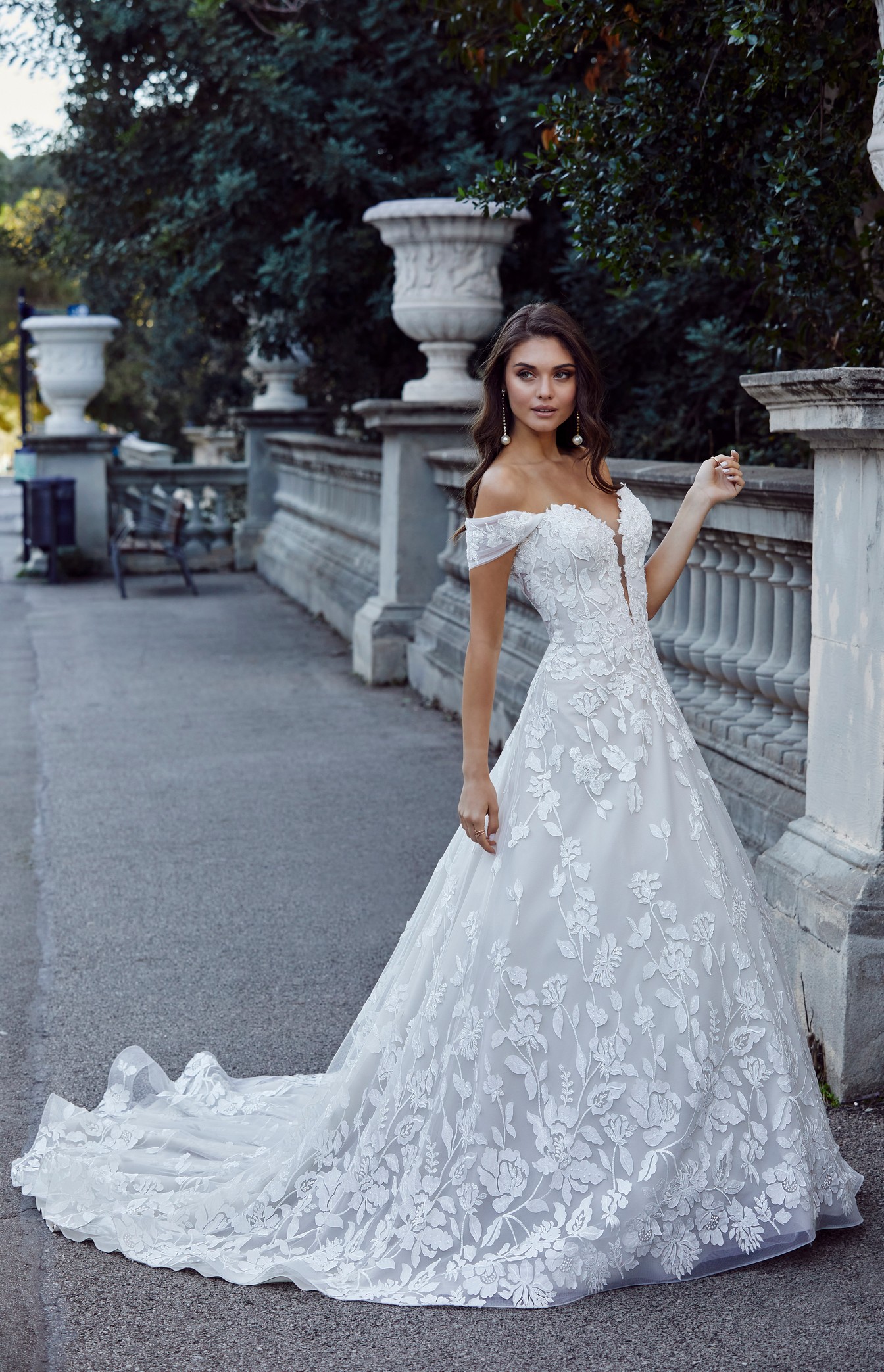 Brunette woman standing outside wearing floral ballgown wedding dress 