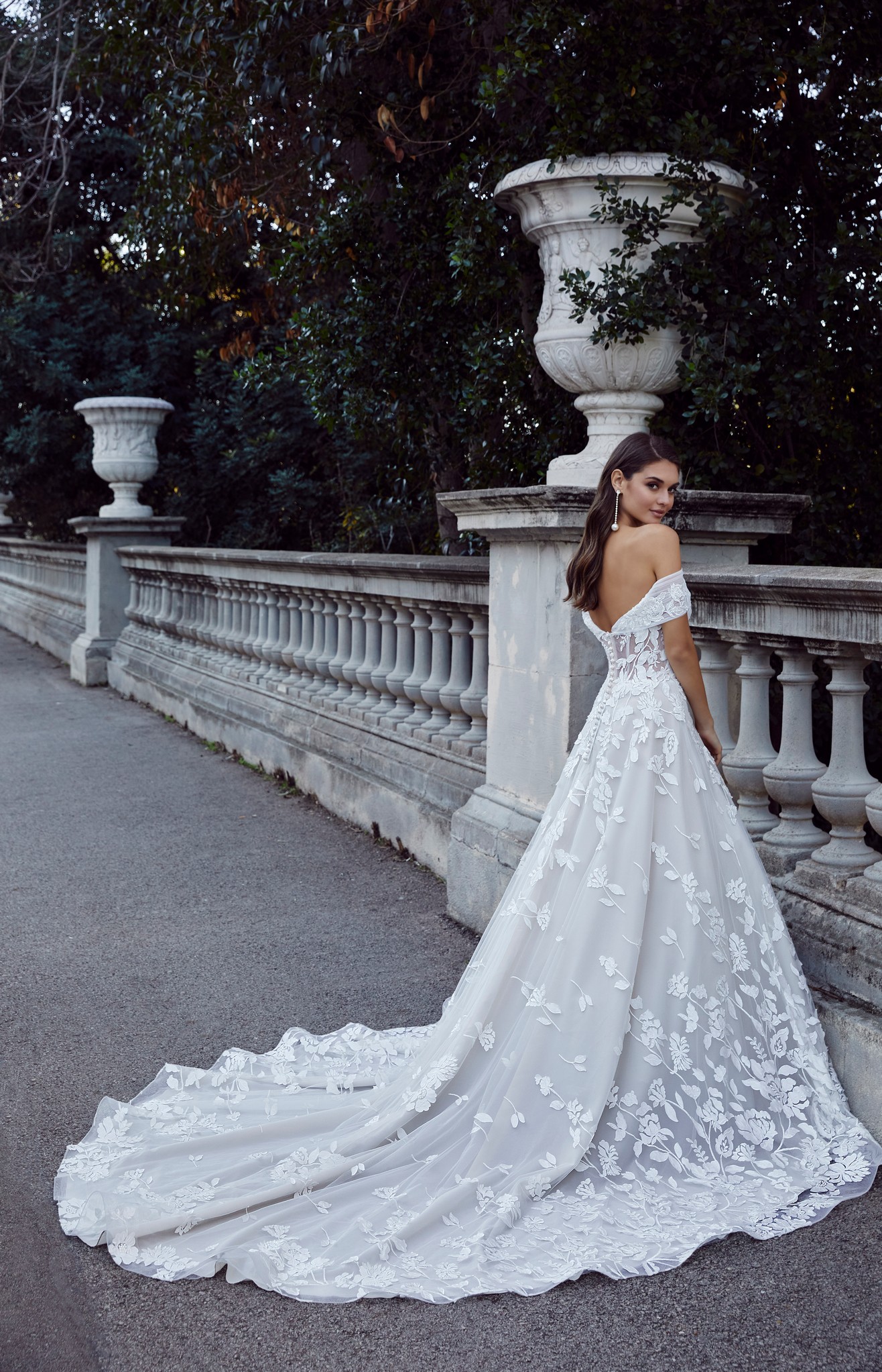 Back image of brunette woman wearing floral lace ballgown wedding gown